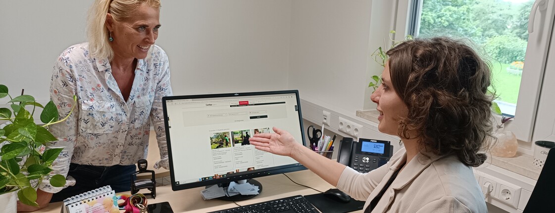 Freiwilligenmanagement Zwei Frauen im Büro, sie sprechen miteinander, eine von ihnen ist am Laptop.